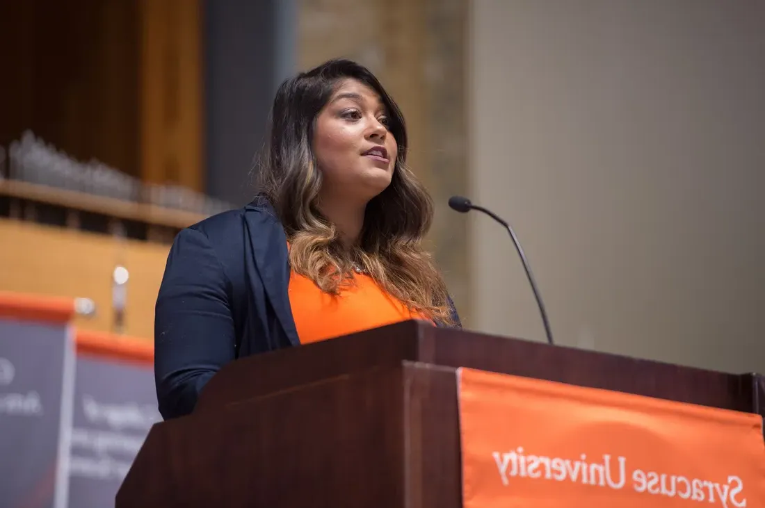 A person speaking at a podium.